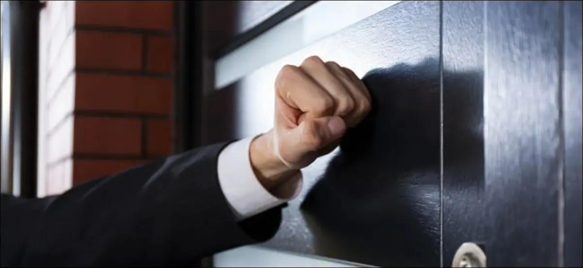 Hand klopft an eine geschlossene Tür.