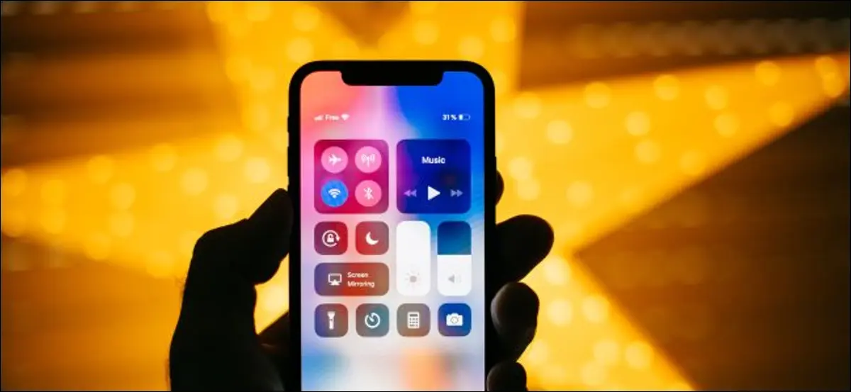 Eine Hand hält ein iPhone X mit geöffnetem Kontrollzentrum.