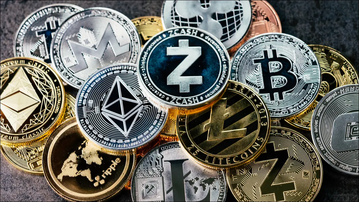 Fizyczne monety reprezentujące kryptowaluty Bitcoin, Ethereum, Litecoin, zcash i ripple.