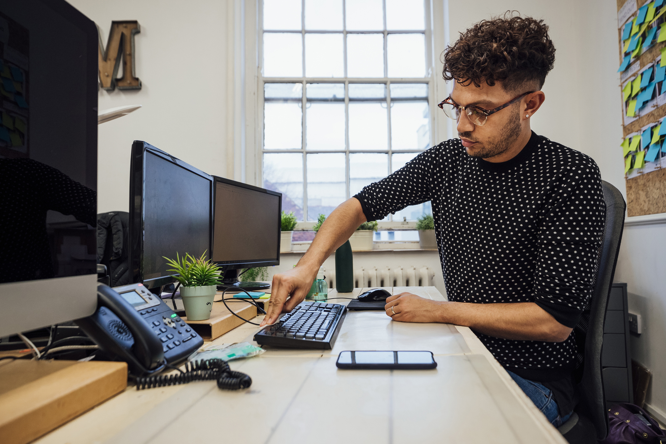 bărbat care curăța tastatura unui computer desktop