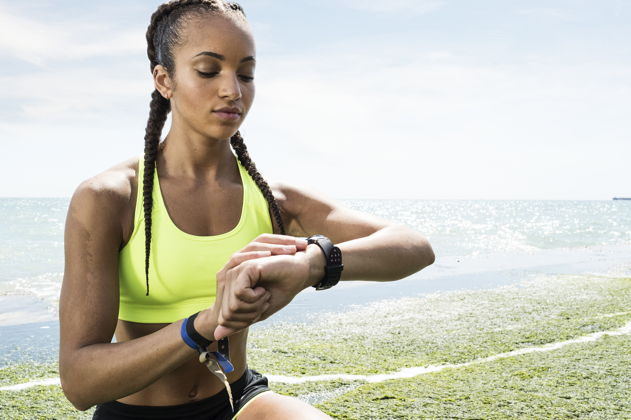 femeie care se uită la un tracker de fitness pe încheietura ei