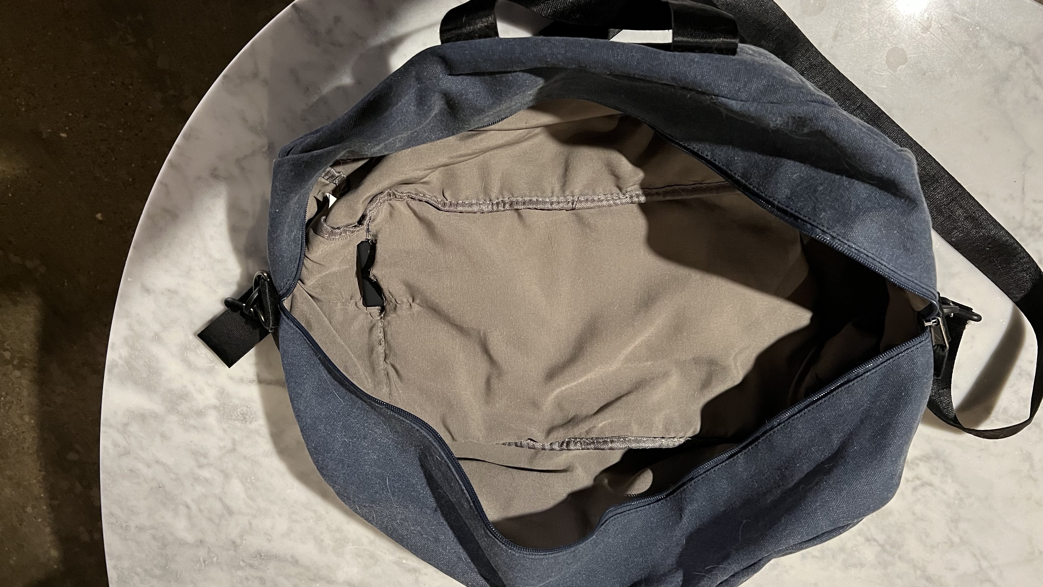 Offene Tasche mit Bluetooth-Tracker unter der Naht.