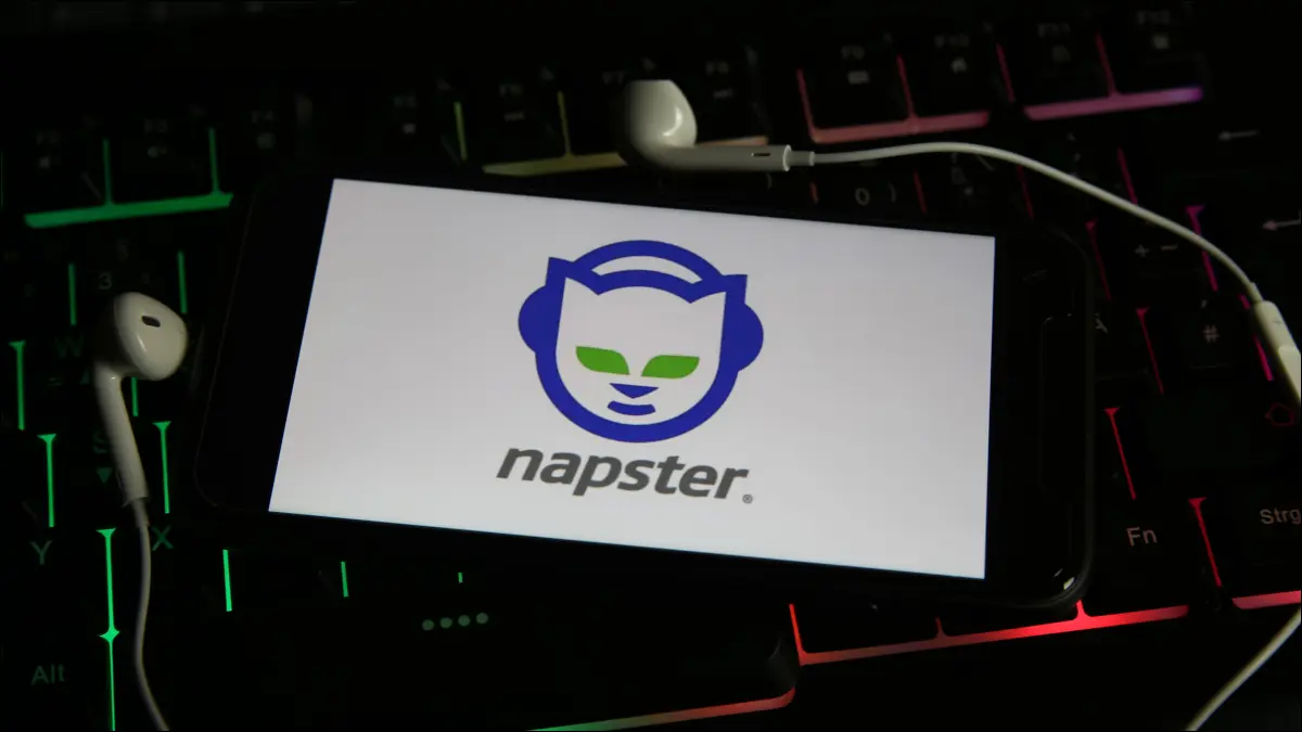 Smartfon z logo Napstera i otoczony dołączonymi nausznikami.