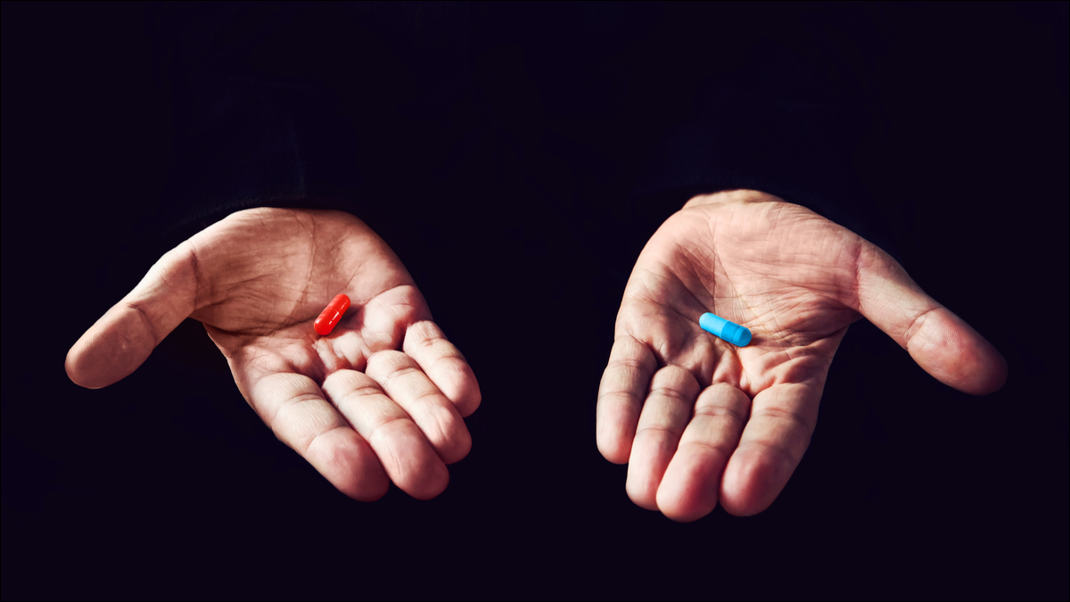 2つの手、1つは赤い錠剤を持ち、もう1つは青い錠剤を持っています。