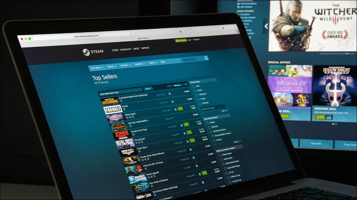 Laptop otwarty na wyprzedaż Steam, pokazujący zniżki na gry.