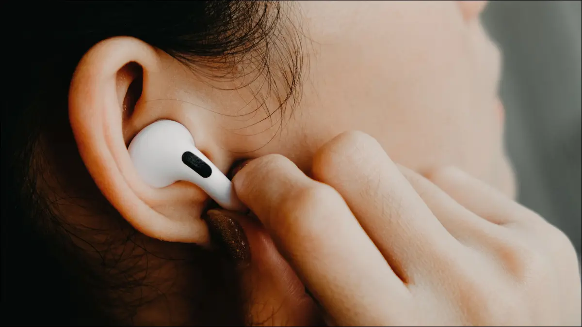 Persona que usa los controles táctiles en Apple AirPods