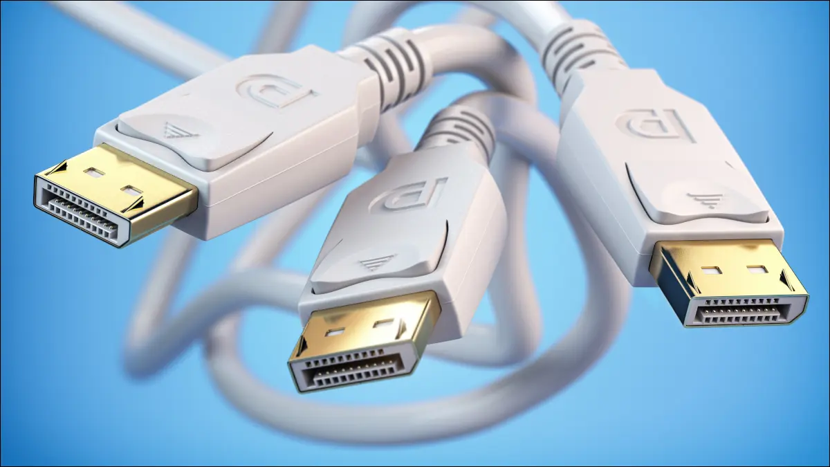 Trzy białe kable DisplayPort splątane razem na niebieskim tle.