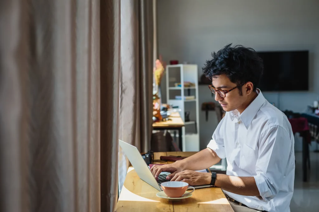 Seseorang bekerja dengan laptop di kedai kopi.