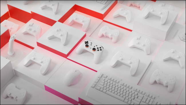 ตัวควบคุม Google Stadia นั่งอยู่ท่ามกลางตัวควบคุมที่ว่างเปล่าและเปลือกคีย์บอร์ด