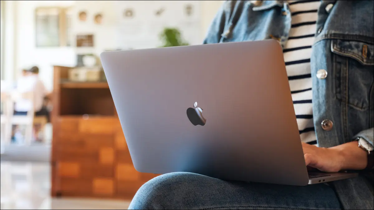 Bir kafede kucağında MacBook kullanan kişi