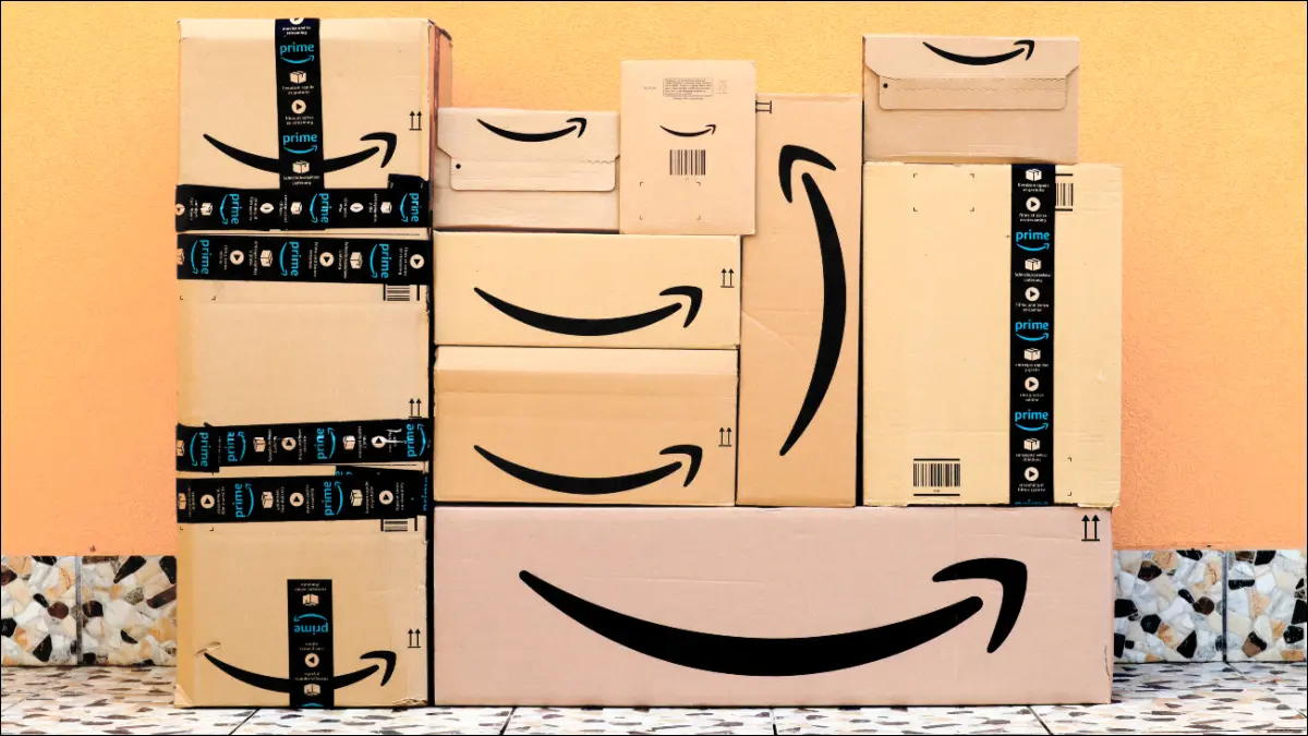 Amazon-Kisten stapeln sich vor einer gelben Wand