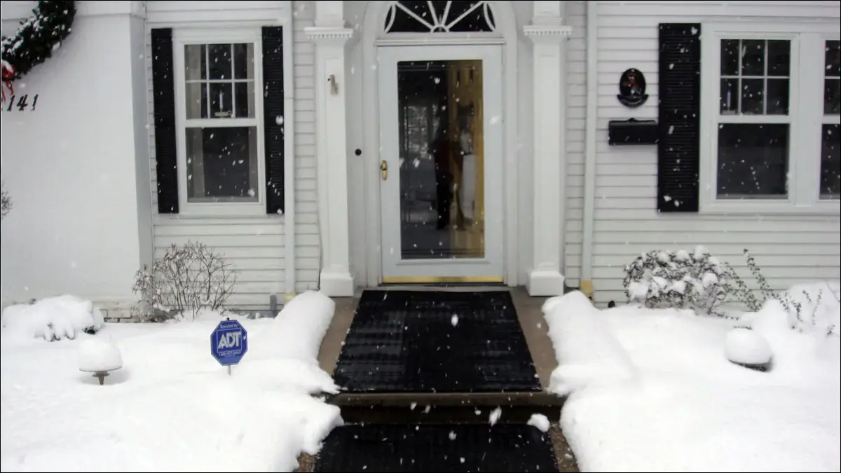 Bir evin ön kapısına çıkan yürüyüş yoluna yerleştirilen buz eritme paspasları.