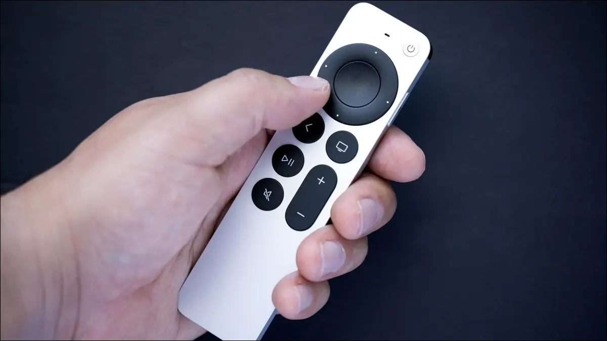 Un control remoto plateado de Apple TV en la mano de una persona.