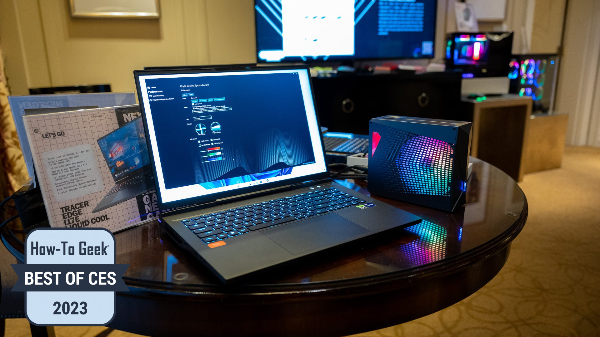 Laptop CyberPowerPC Tracer Gaming I17E Liquid Cool așezat lângă rezervorul său de răcire cu apă