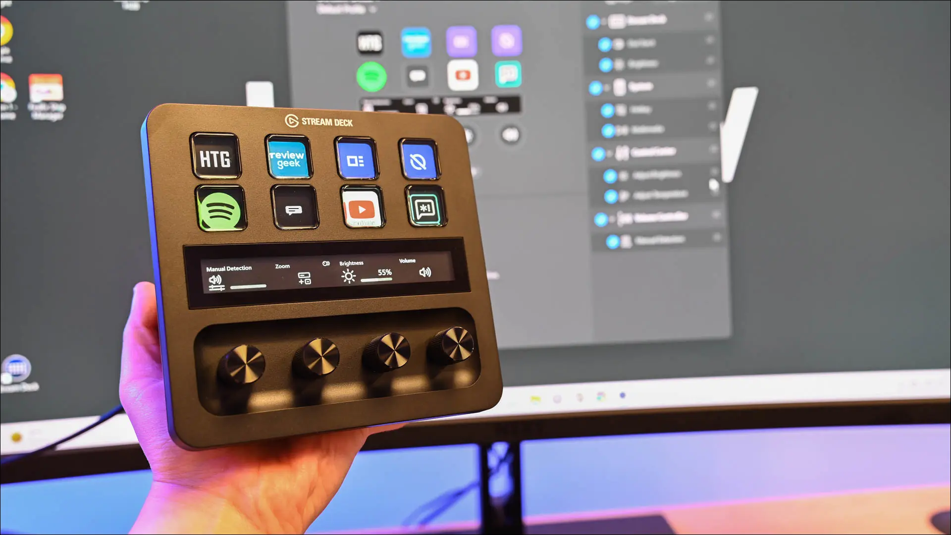 持有 Elgato Stream Deck + 電腦旁邊的人