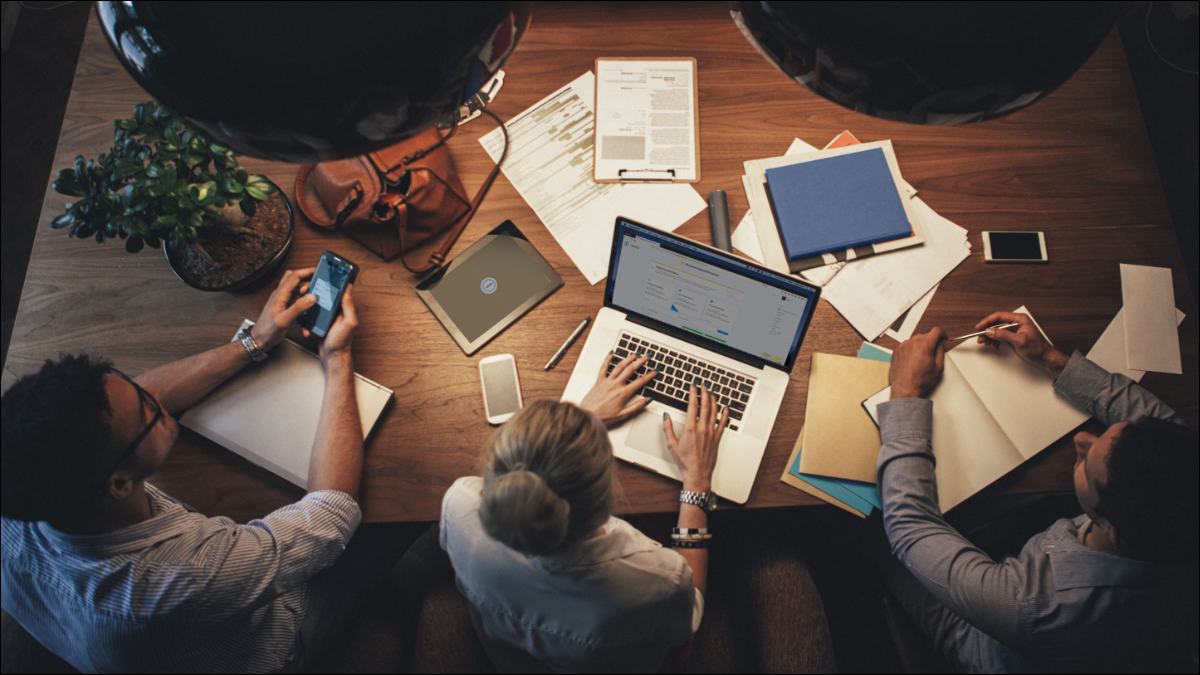 persone che lavorano attorno a un laptop