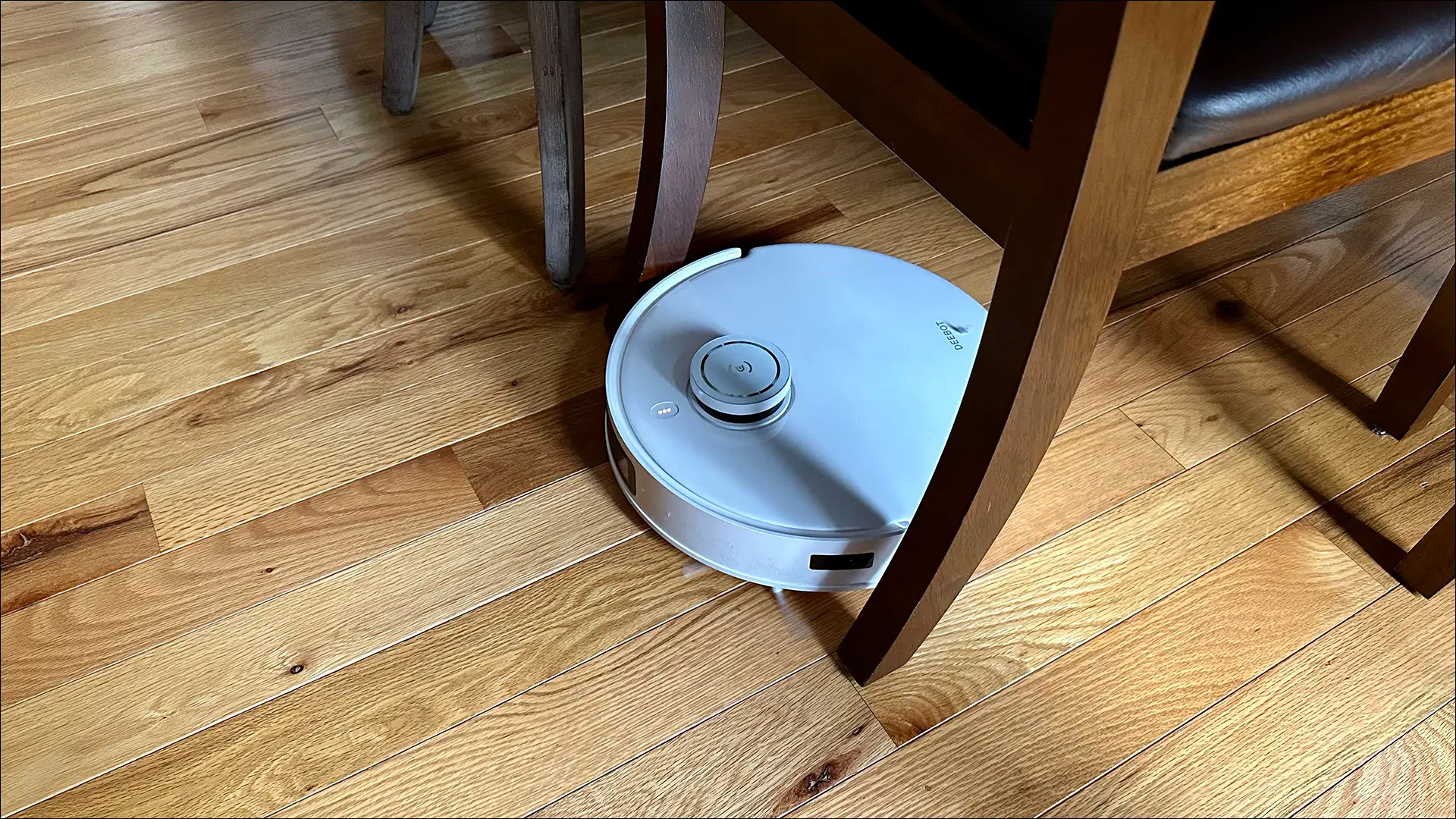 Le Robot DEEBOT T10 OMNI aspire les parquets entre les pieds des chaises